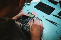 A man, working on the internals of a smartphone