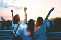 Three people looking towards the horizon, beeing happy